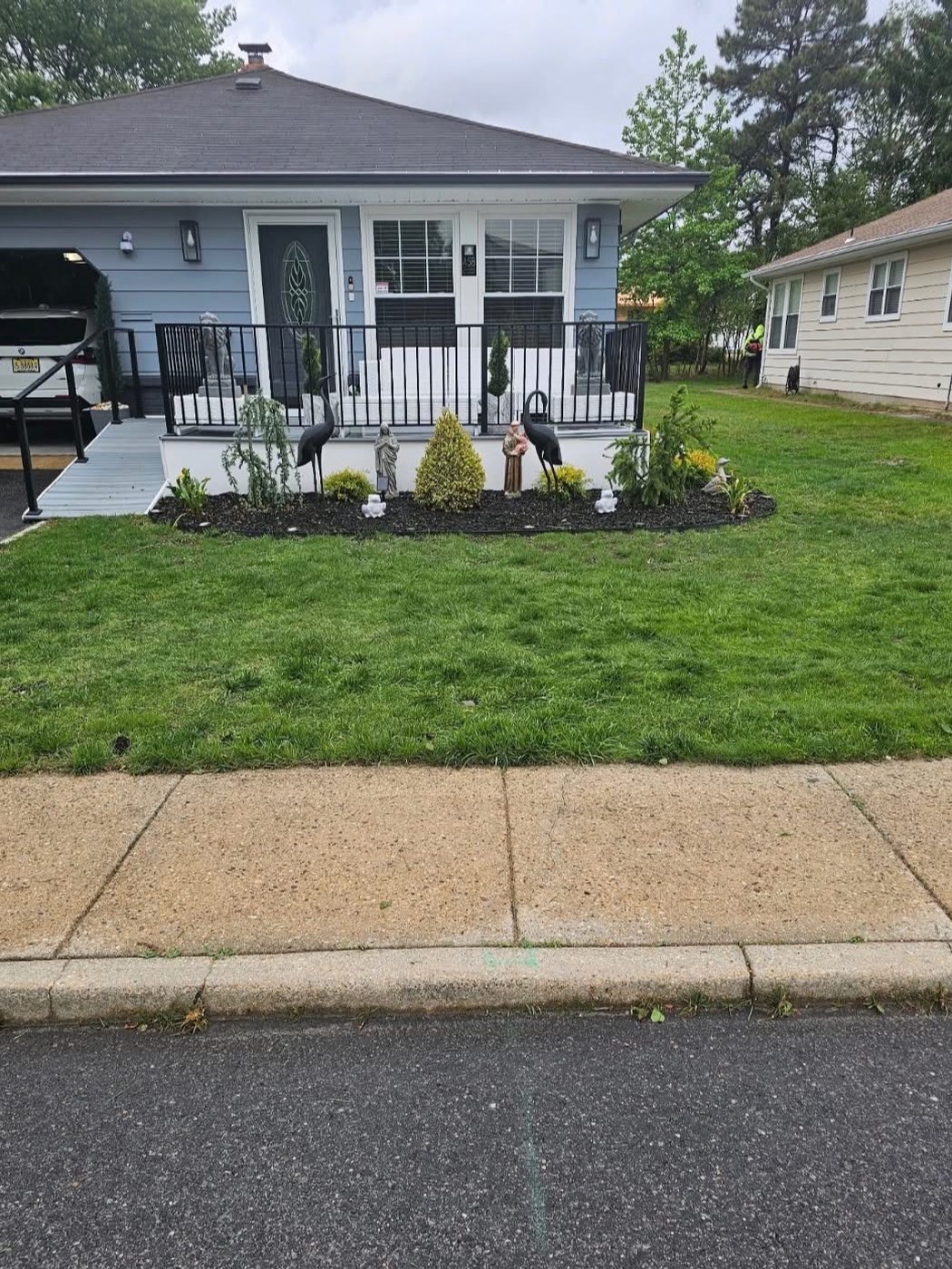 The same front lawn grown in thick and green beside fresh mulched beds