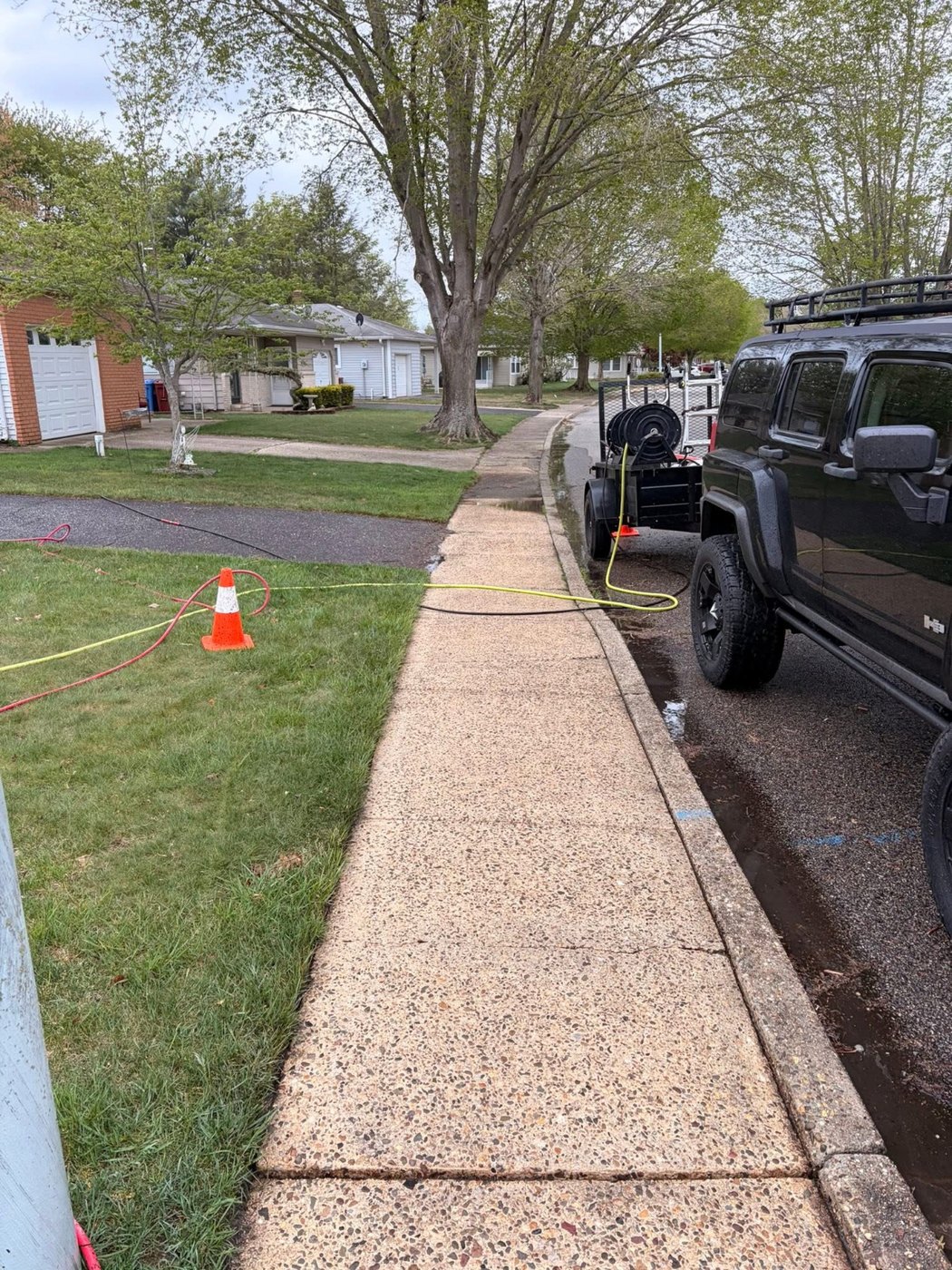 The same sidewalk pressure-washed back to bright, clean concrete